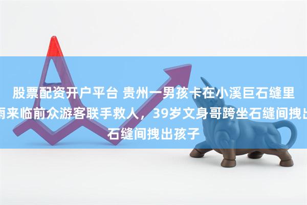 股票配资开户平台 贵州一男孩卡在小溪巨石缝里，大雨来临前众游客联手救人，39岁文身哥跨坐石缝间拽出孩子